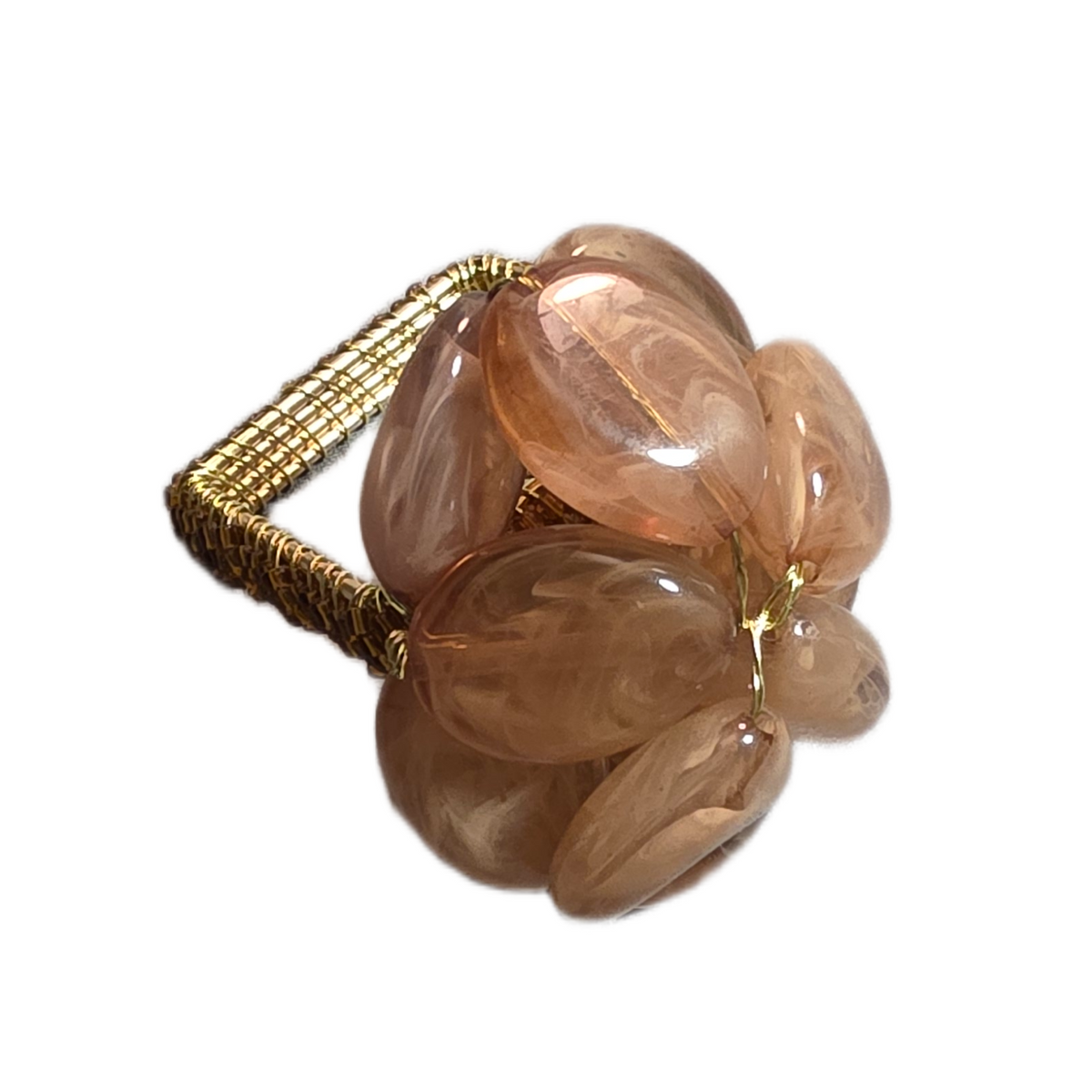 The Pebbles Napkin Ring Set of 4 in Caramel by Iza Silva features smooth, oval peach-toned stones wrapped in gold wire, creating a handcrafted accent to elevate your luxury table decor. Displayed on a white background.