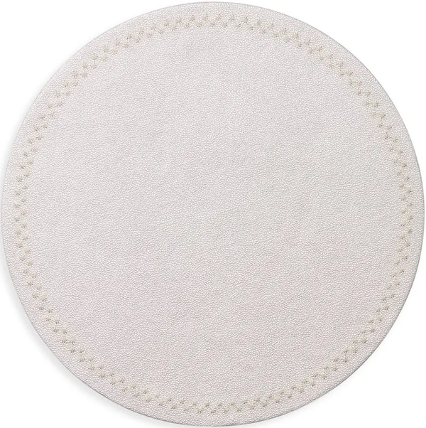 The Starry Night Placemat s/4 by Kim Seybert features a round, light beige textured design with subtle stitching and metallic trim—an easy-to-clean placemat that brings elegance to any table setting.