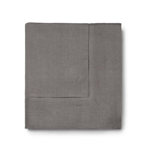 The Sferra Festival Tablecloth is a neatly folded gray fabric with a decorative hemstitch border, shown against a white background.