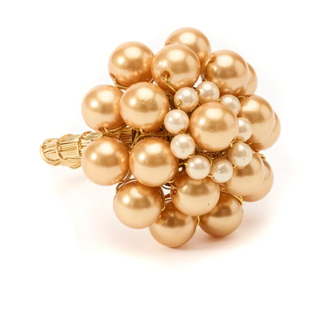 The Deborah Rhodes Jeweled Dome Napkin Ring Set of 4 features rounded gold designs with large and small pearls, inspired by cluster-style rings, adding an elegant, designer touch to your table décor.