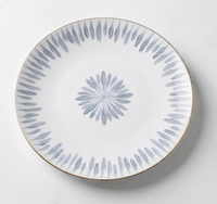 The Marie Daâge Allee de Cypres 4 plate by Marie Daâge is a white ceramic piece with a thin gold rim and blue-gray leaf motifs, showcasing luxury tableware and timeless hand painted dinnerware artistry.