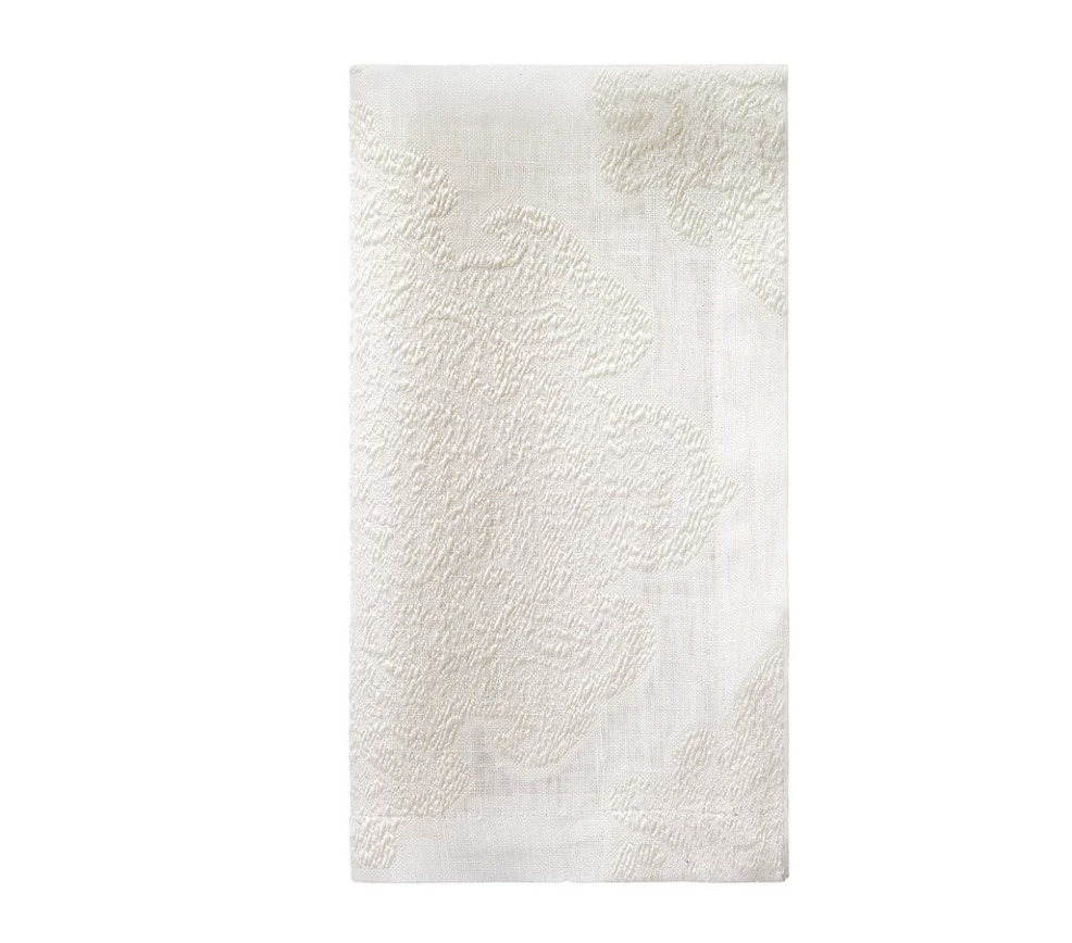 The Bodrum Castille Napkin Set of 4 in Oyster features a white, textured cloth design with a subtle raised floral or leaf pattern, elegantly displayed flat against a white background.