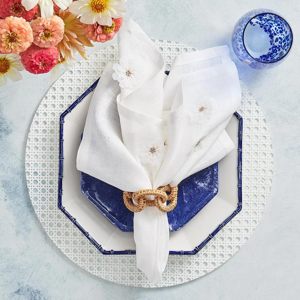 Reed Placemats Set of 4 - White displayed on a tablescape with blue tableware. 
