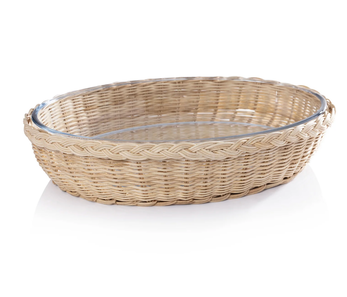 A round, shallow Palmetto Oval Baker by Zodax, featuring a wicker basket with a braided rim and a glass dish insert, placed on a white surface.