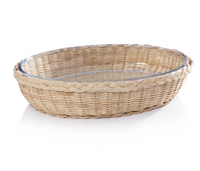 A round, shallow Palmetto Oval Baker by Zodax, featuring a wicker basket with a braided rim and a glass dish insert, placed on a white surface.
