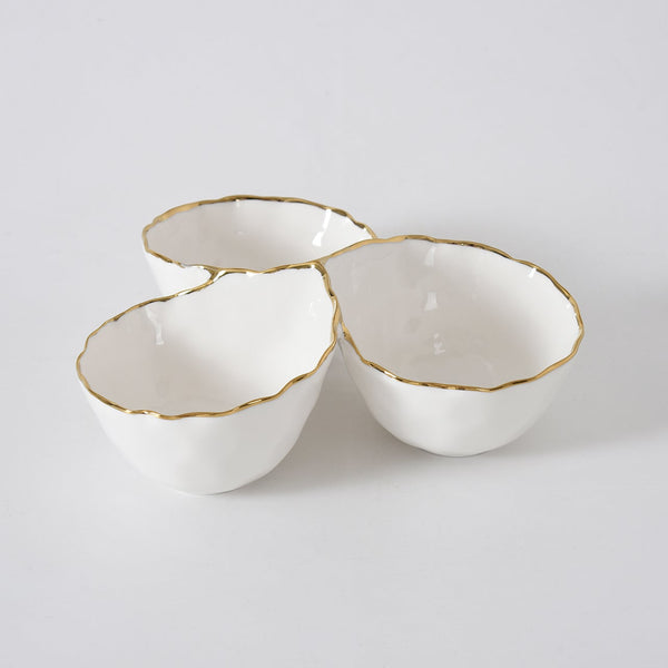 Three connected white porcelain bowls from PAMPA BAY’s Portofino Gold 3 Section Server, each adorned with uneven gold trim, are arranged in a cluster on a plain white background. This elegant server is perfect for stylish entertaining.