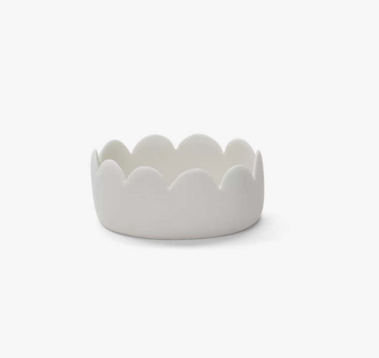 A small, white ceramic Tina Frey Fleur Oval Bowl, featuring a smooth, scalloped edge, set against a plain white background.