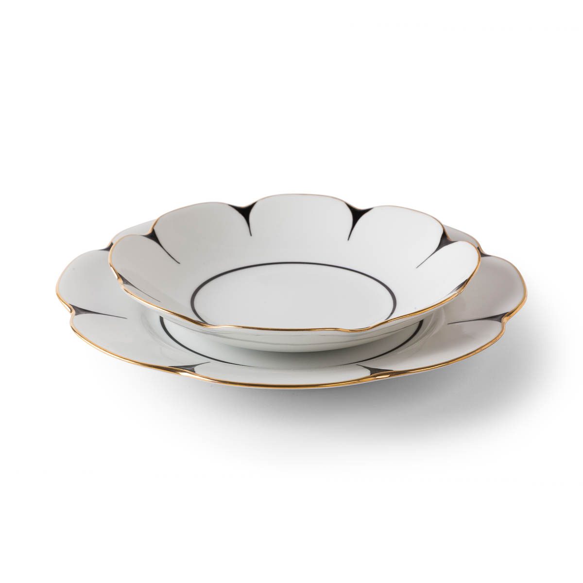 Two white Drops Dinnerware plates by Molecot, crafted from porcelain with scalloped flower-shaped edges, are stacked together. Each plate is adorned with a fine gold-finished rim and a delicate black accent outlining the edges. The background is pure white.