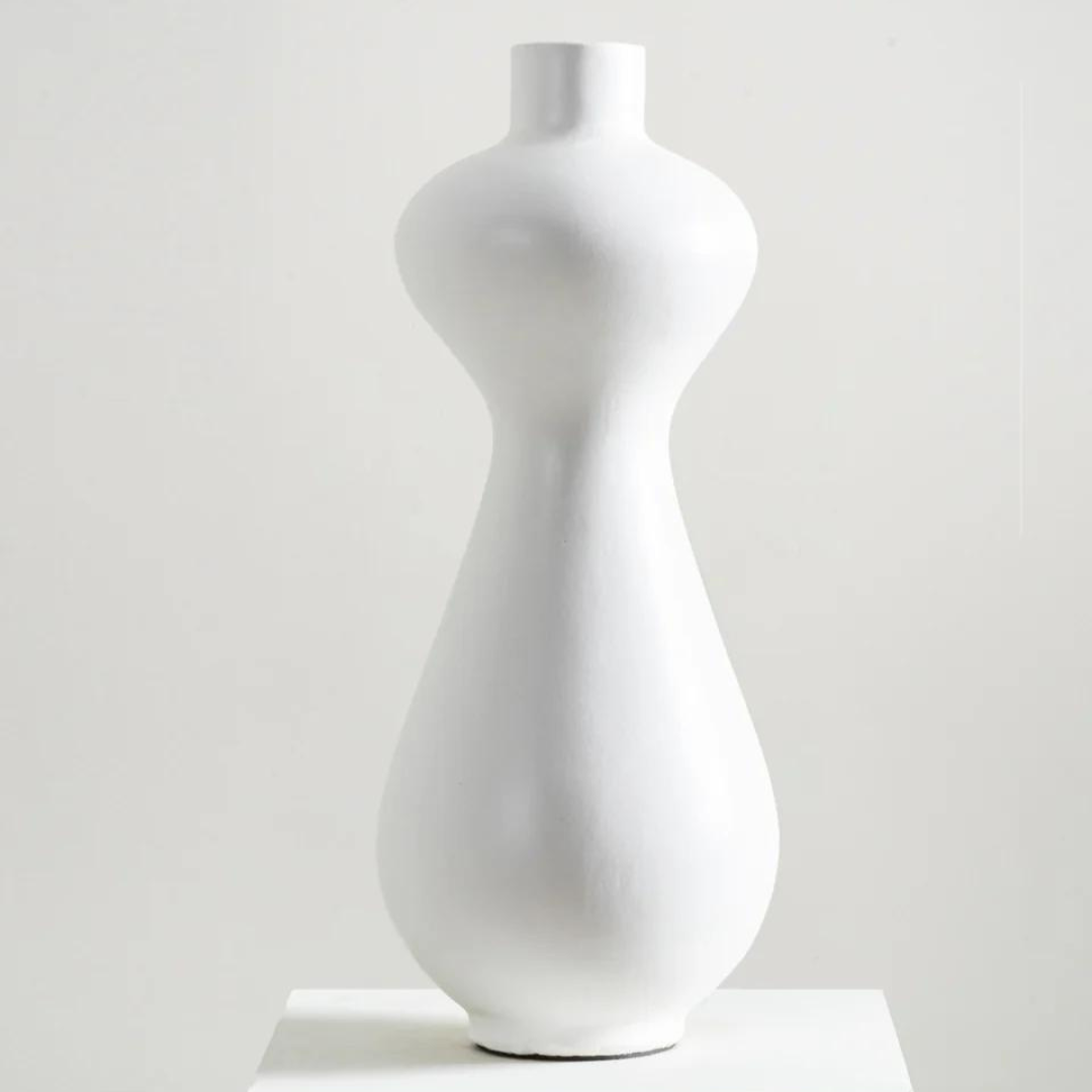 Skyline Vase - White is displayed on white pedestal table. 