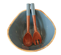 The Indy Home Montauk Serving Bowl With Servers features a blue ceramic bowl with a natural wooden rim and matching wooden fork and spoon, creating a charming handmade set perfect for any salad occasion.