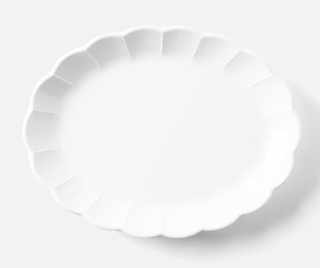 The Blue Pheasant Iris Melamine Dinnerware Oval Serving Platter 16" features a glossy white finish with scalloped edges, displayed empty on a light, neutral background.