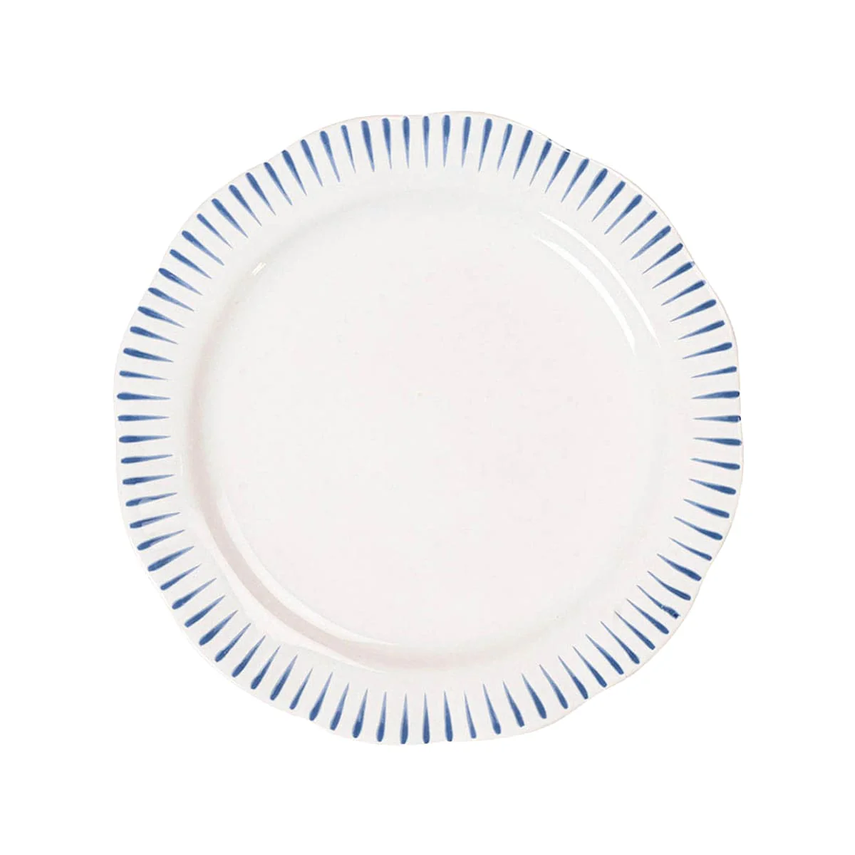 The Sitio Stripe Dinnerware by Juliska is a round white dinner plate with a scalloped edge, whitewash glaze, and evenly spaced short Delft blue lines along the rim.
