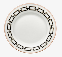 The Catene Nero Dinnerware by Ginori 1735 features a white ceramic plate adorned with a bold black chain-link geometric border and finished with a delicate gold edge.