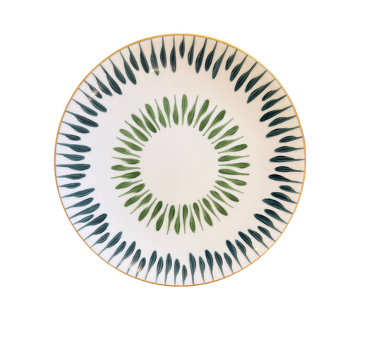 The Marie Daâge Allee de Cypres 5 Platinum Rim features a round white plate adorned with platinum edging and decorated with concentric circles of green and dark teal leaf-like patterns around the rim and center.