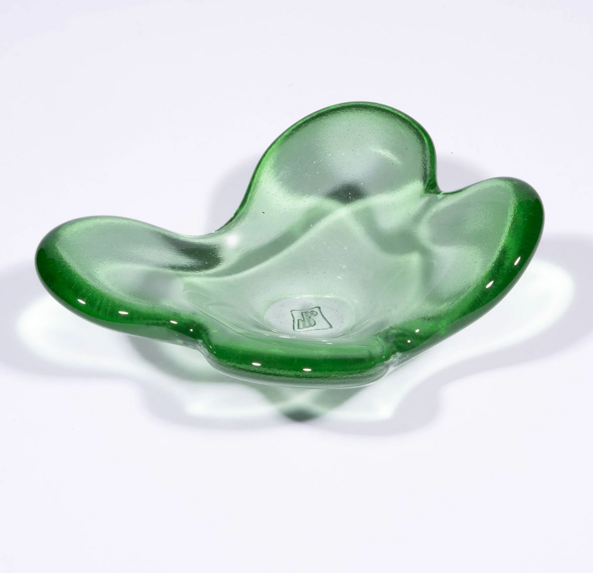 The Cloud Dish by Tyler Barry Design is a green, translucent hand-blown glass bowl with an abstract wavy shape and smooth surface, photographed on a white background—a striking decorative accent for any space.
