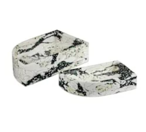 The Fallon Stone Curved Tray Set by Currey & Company includes two white composite stone trays with black and green marbling, boasting a modern geometric look and gently curved edges—ideal as decorative soap dishes.