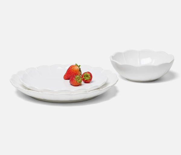 Three Iris Melamine dishes by Blue Pheasant are arranged on a white surface: two stacked plates with three strawberries on top and a matching bowl nearby.