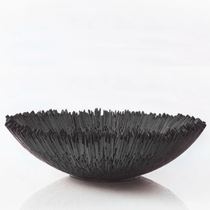 The Boracay Centerpiece Bowl by Quilted Koala is a round, black decorative bowl with an uneven, spiky rim reminiscent of clustered sticks. Handcrafted from reclaimed mahogany in the Philippines, this sculptural piece stands out as a striking centerpiece, displayed here against a plain white background.