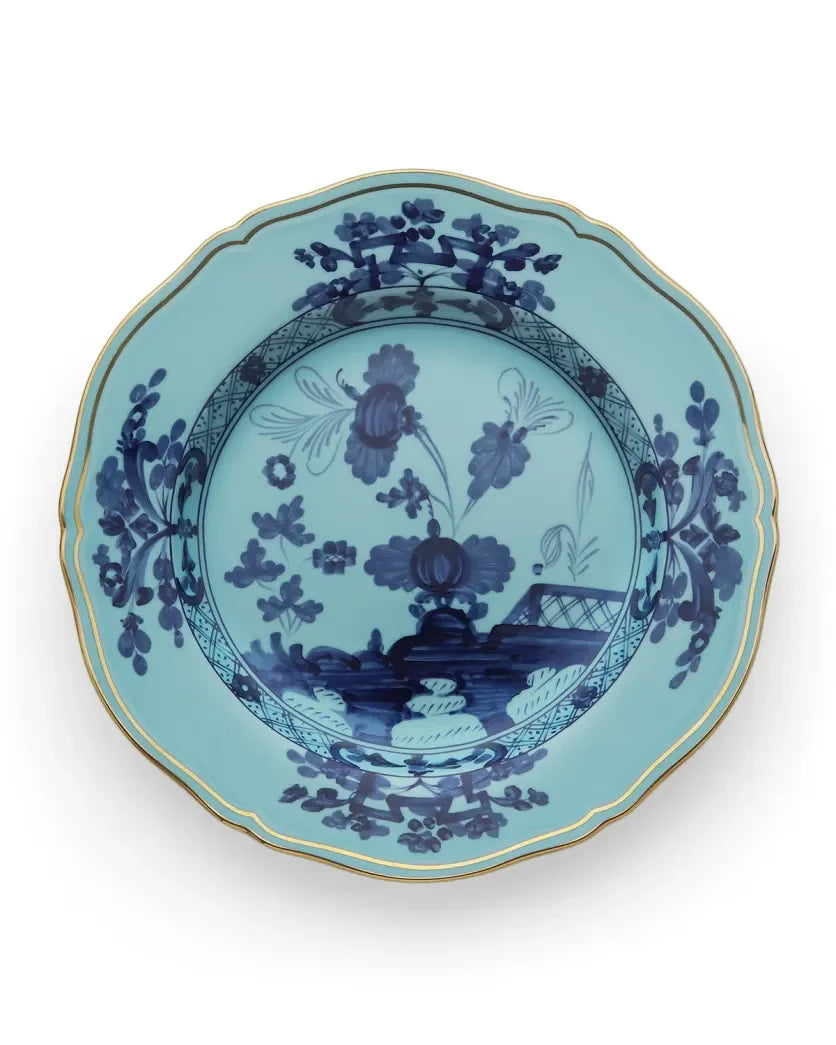 Light blue Ginori 1735 Oriente Italiano Dinnerware Iris porcelain plate with a scalloped edge, gold trim, and dark blue chinoiserie floral and landscape patterns.