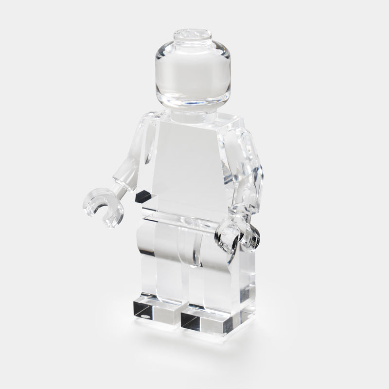 The Luho Brix Sculpture features a clear Lego-style minifigure on a white background, offering a whimsical home accent and unique clear acrylic decor piece.