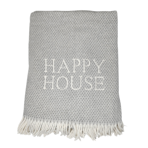 The Happy House Throw by A Soft Idea is a folded gray woven blanket with white fringed edges and "HAPPY HOUSE" embroidered in large white letters. This home exclusive throw is machine washable for easy care.