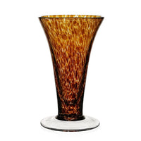 The Vanessa Vase - Tortoise by William Yeoward is a tall, flared glass vase with a wide rim, showcasing mottled amber and brown Mediterranean tones and a clear, round base.