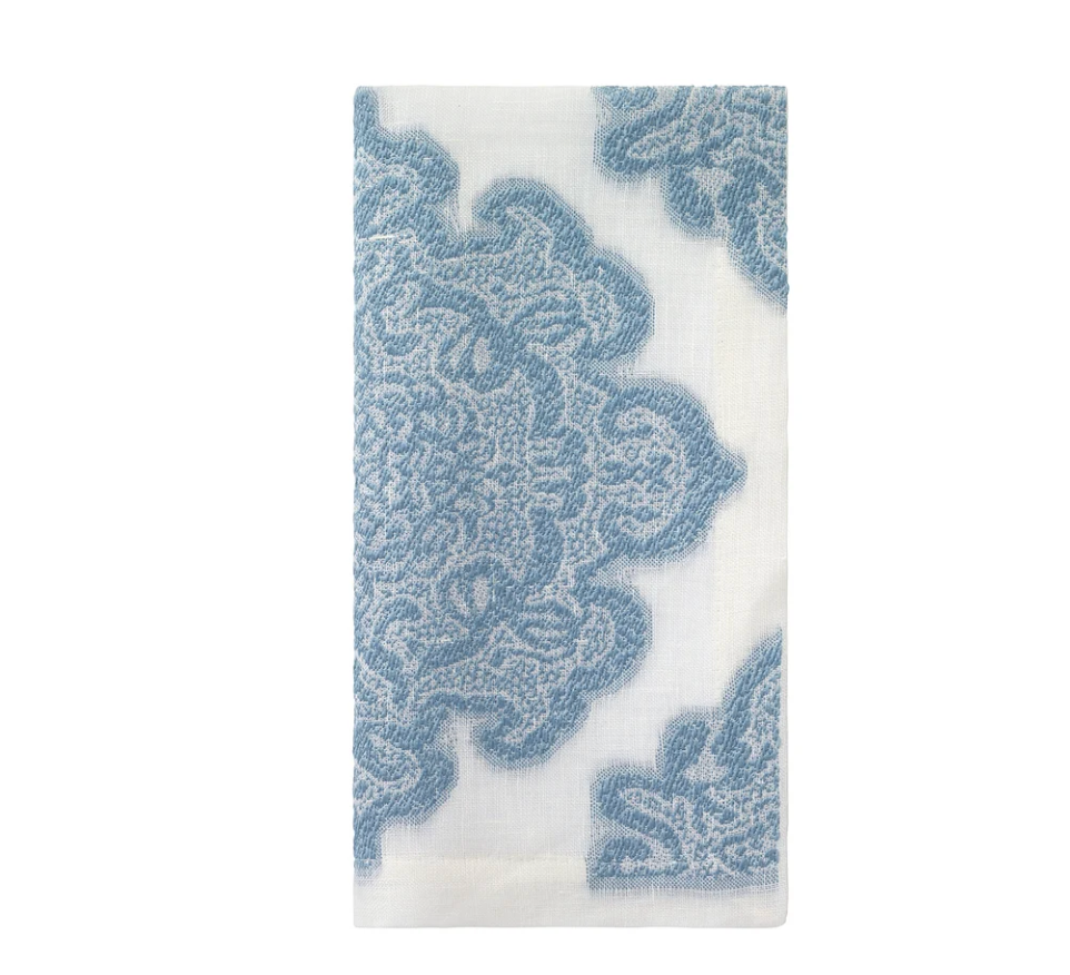 Elevate your dining experience with Bodrum’s Castille Napkin Set of 4 in Ice Blue. Each white napkin features a delicate ice blue floral or lace-inspired embroidered design, artfully positioned so the motif graces the bottom right and upper left corners when neatly folded. A highlight from our Castille table linens collection, these elegant napkins are perfect for pairing with matching table runners or additional linens to create a sophisticated and cohesive tablescape.
