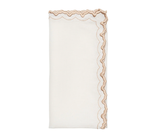 The Kim Seybert Arches Napkin Set of 4 features folded white linen napkins with wavy, scalloped edges, tan stitching, and embroidered detailing along one side.