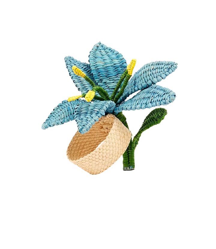 The Coro Cora Lily Napkin Ring Set of 4 features handcrafted beige rings with tropical blue floral designs, yellow accents, and green leaves made from textured straw-like material.