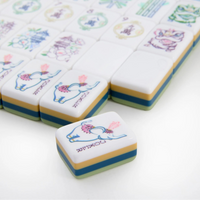A set of vibrant Willow Mahjong Tiles from Oh My Mahjong features an elephant illustration on the visible pieces. One tile from the elegant Mahjong Tiles Set - Willow is separated and placed prominently in the foreground.