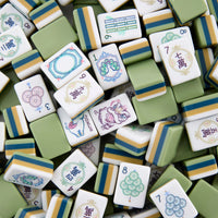 A collection of elegant tiles from the Oh My Mahjong brand’s Mahjong Tiles Set - Willow, featuring various designs, numbers, and Chinese characters in a refined green, white, and yellow color scheme. Some tiles are delicately adorned with subtle floral patterns, adding an extra layer of sophistication to this Willow Mahjong set.