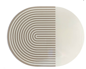 The Von Gern Home Stripes & Solids Lacquer Placemat Set of 4 features oval placemats with a bold beige and white color-blocked design—half with curved beige stripes, half solid white—for a modern table setting.