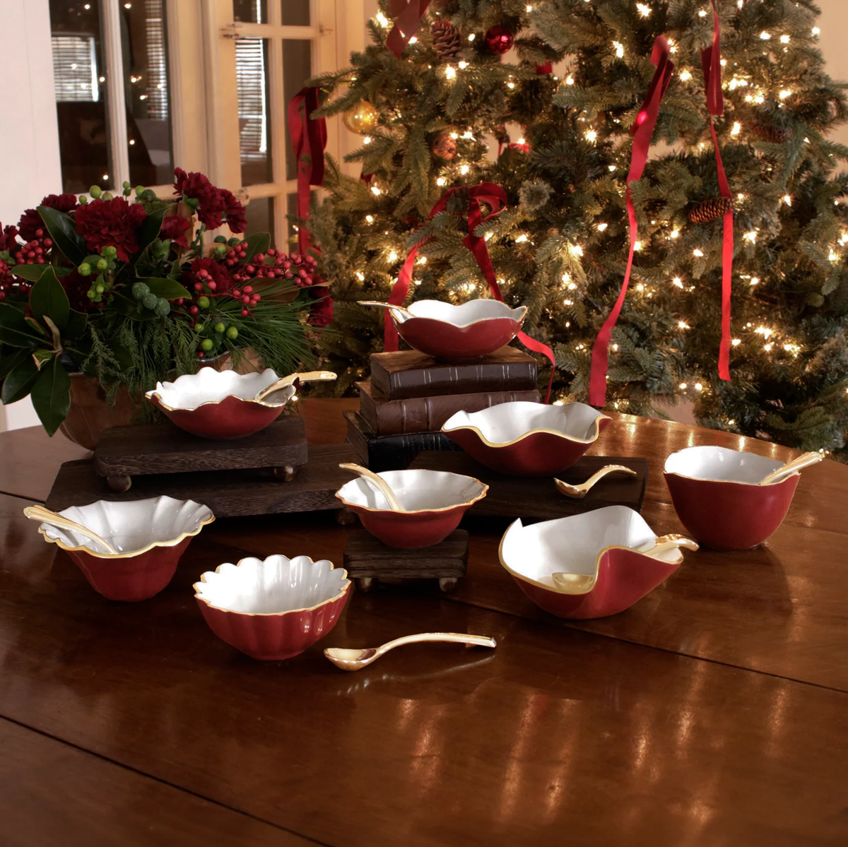 Beatriz Ball Encanto Aries Mini Bowl w/ Spoon - Bordeaux & White sets with gold trim arranged on a wooden table in front of a decorated Christmas tree.