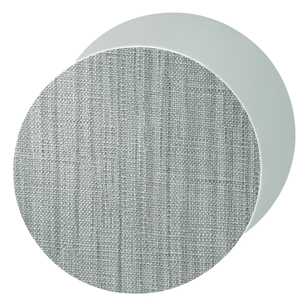 The Bodrum Izmir Placemat Round s/4 features a modern design with two overlapping circular panels—one with a textured light gray fabric pattern in front and a smooth, solid light gray panel at the back.