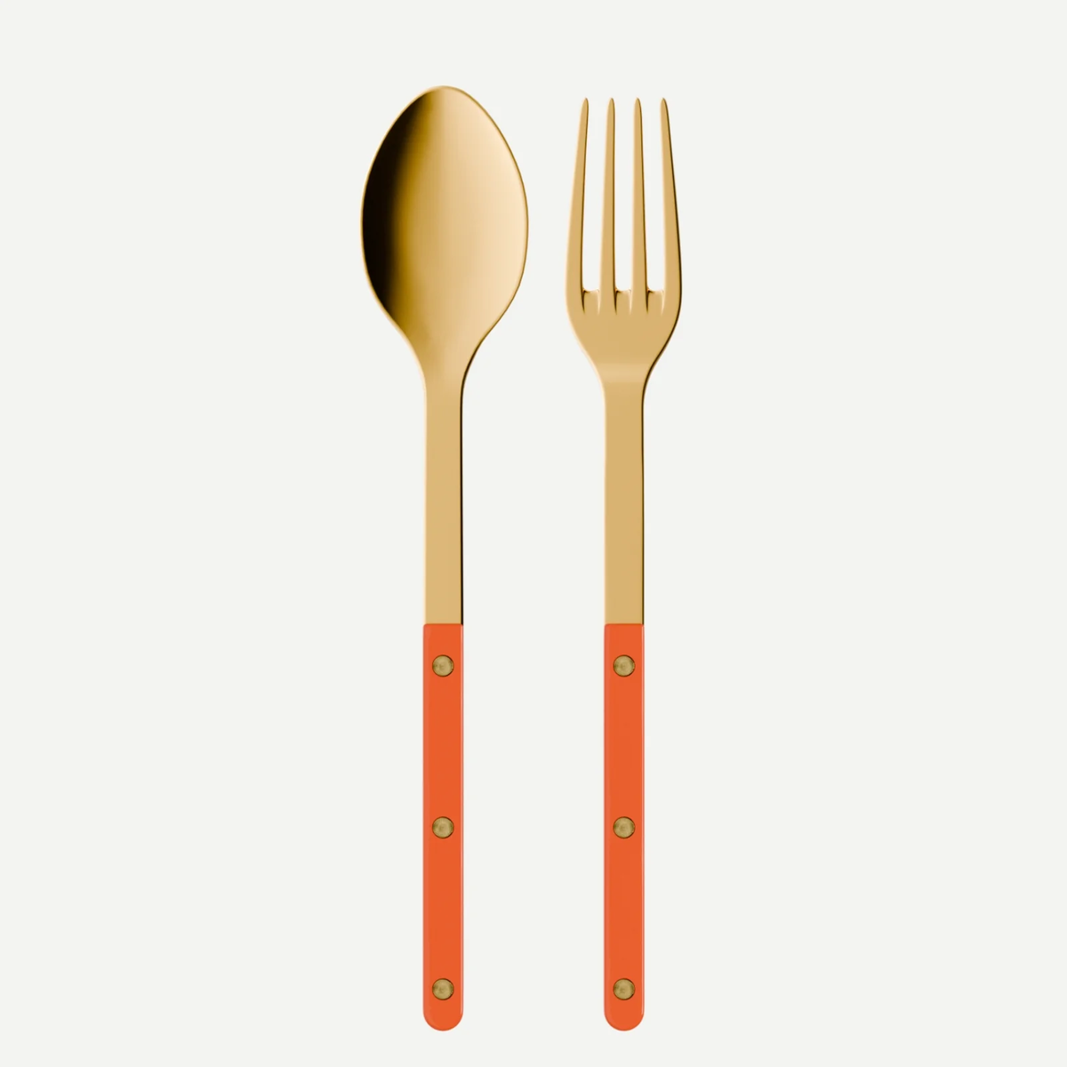 The Sabre Bistrot Gold Serving Set – Orange, featuring a gold spoon and fork with glossy orange handles and gold rivets, is displayed side by side on a white background.