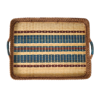The Juliska Danish Stripe Serving Tray Navy 21" features raised edges, side handles, and brown braided edging. Crafted from natural cane wood, it has a Scandinavian design with blue, red, and beige stripes plus small square base accents.