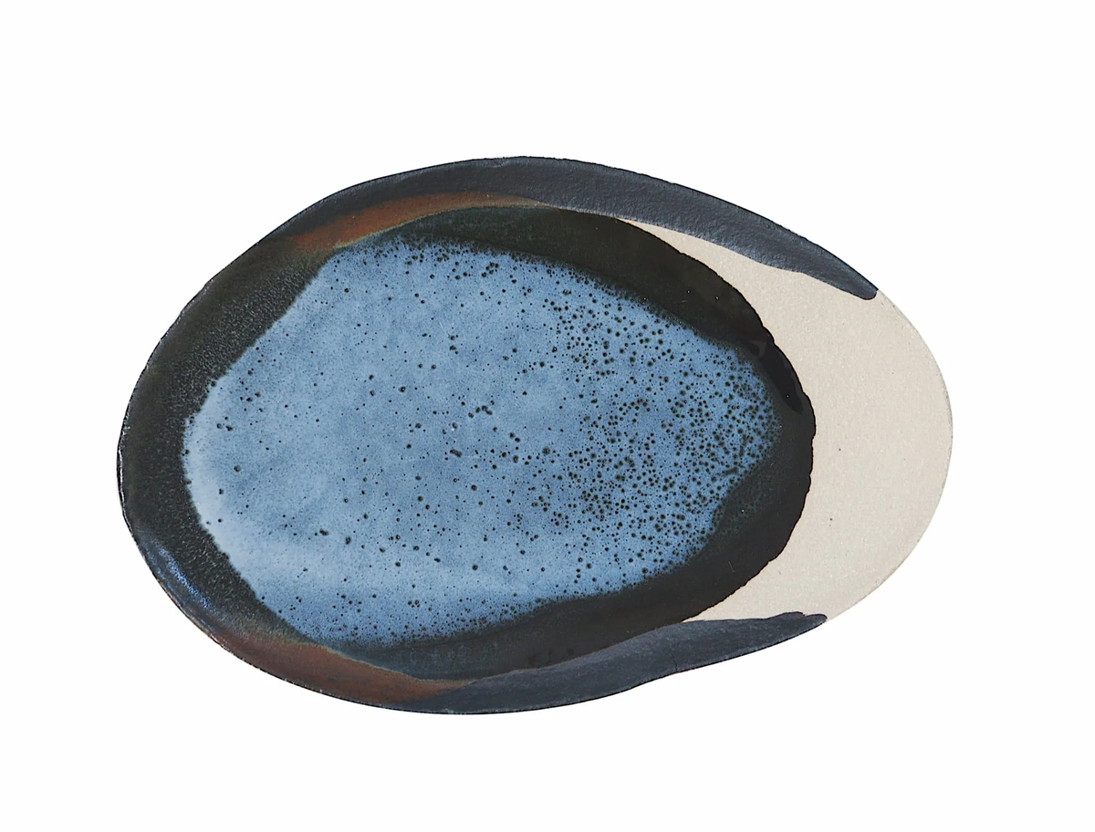 The Wabi Oval Dish Awa by Jars - Rosenthal is a ceramic plate with a blue, speckled center and dark and light tan edges, displayed against a white background.