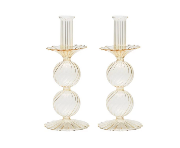 The Bella Candlestick Holder Set of 2 by Kim Seybert showcases two elegant candlestick holders crafted from hand-blown glass, featuring ribbed, spherical shapes stacked vertically and a fluted base, displayed against a plain white background.