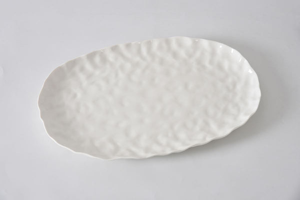 The PAMPA BAY Willow White Platter Oval Large features a textured, slightly wavy ceramic surface and edges in a spacious, empty white design, displayed on a plain white background.