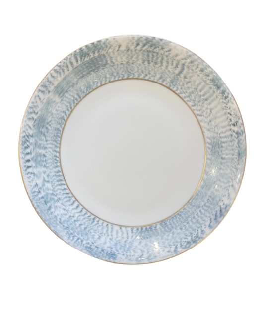 The Marie Daâge Agate Border plate by Marie Daâge features a round white ceramic design with a wide, textured blue and white patterned rim and a thin gold accent line, inspired by classic French dinnerware and shown on a white background.