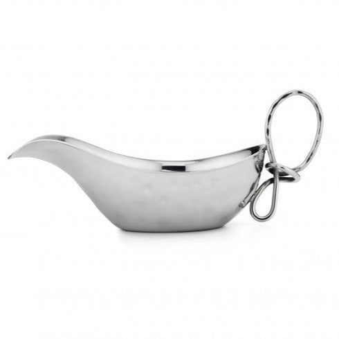 The Mary Jurek Opus Gravy Boat is a shiny handcrafted stainless steel piece with a curved spout, rounded body, and large looped handle, set against a plain white background.