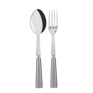 The Sabre Icone Serving Set features a stainless steel spoon and fork with shiny, reflective surfaces and thick silver handles, displayed side by side on a white background.