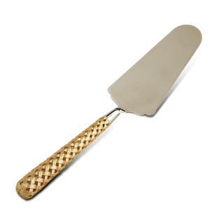 The Braided Cake Server by L'Objet features a broad metal blade and a woven straw handle, part of the Braid Serveware collection, shown isolated on a white background.