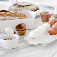 The white condiment bowl is paired here with other stoneware items from the same collection. 