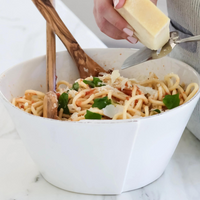 The large stoneware bowl features a large pasta dinner. 