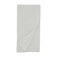 A neatly folded Simple Linen Napkin from Saro Trading is displayed on a white background, with one corner slightly turned up to reveal the hemmed edge—an elegant example from their White Set of 4 classic linen napkins.