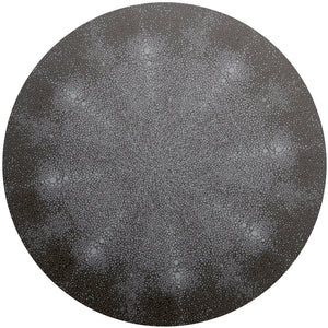 The Shagreen Placemat by Tisch New York features a detailed pattern of small, interconnected white dots radiating in symmetrical shapes on a dark grey background, resembling a mandala or cell-like structure.