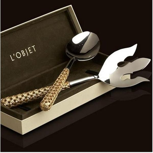 The Braid Serving Set Gold by L'Objet features a ladle and decorative fork with woven 24k gold plated handles, elegantly presented in an open L'Objet gift box against a dark backdrop.
