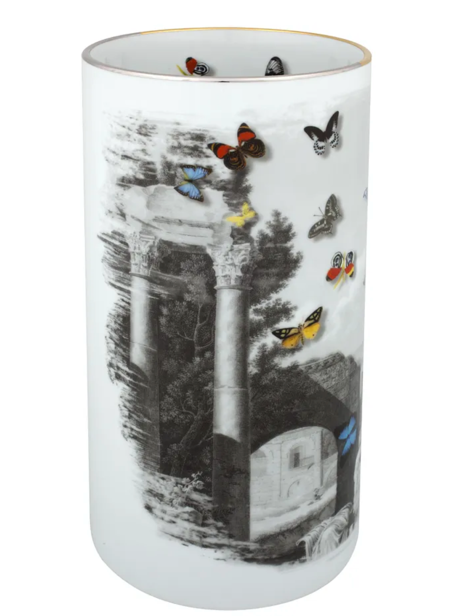 The Large Forum Vase by Christian Lacroix for Vista Alegre is a tall cylindrical porcelain piece adorned with black-and-white classical ruins and arches, accented by vibrant butterflies both inside and on the exterior—seamlessly blending timeless elegance with playful artistry.
